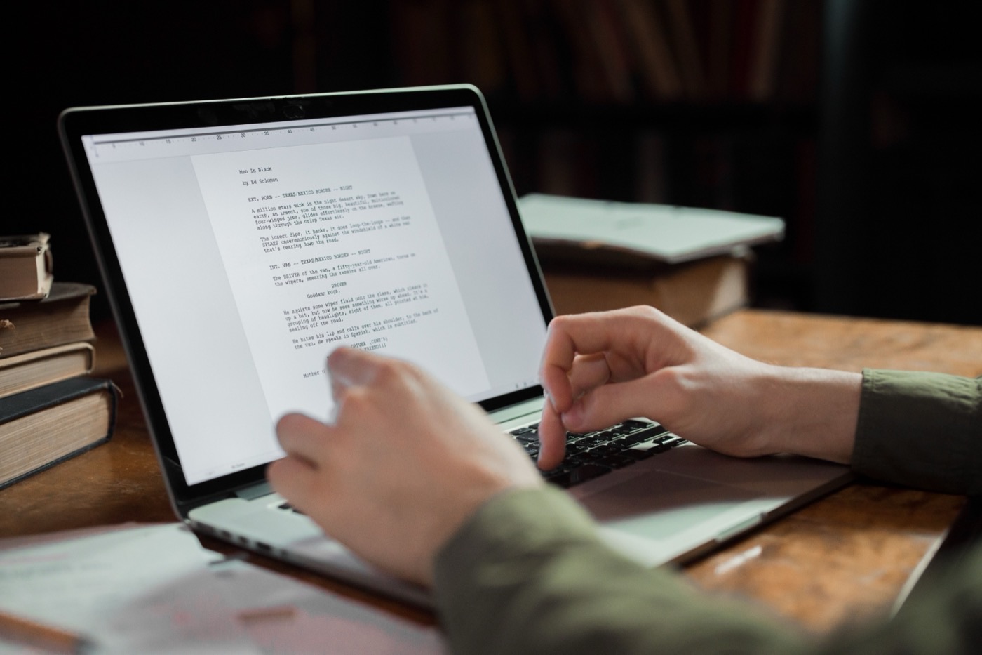 Hände tippen ein Textdokument auf einer Laptop-Tastatur