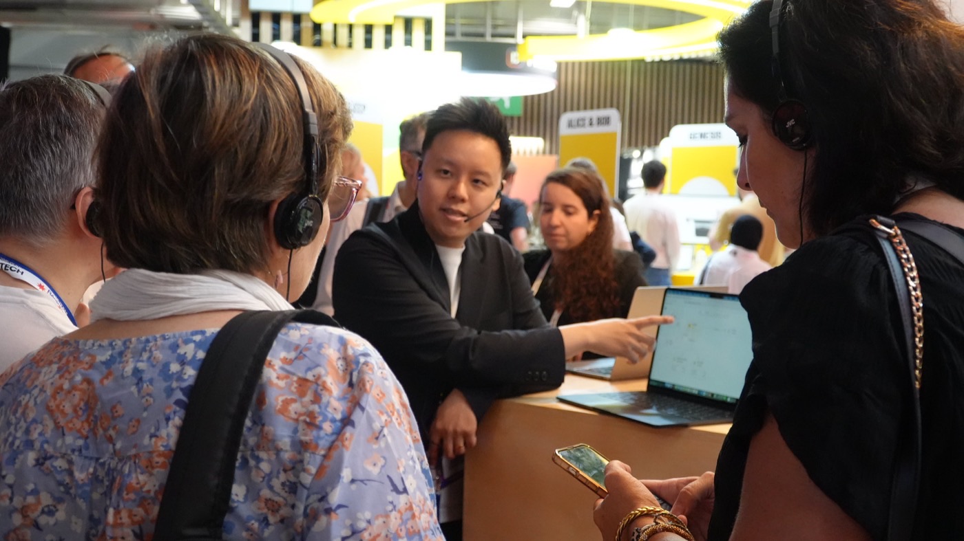 Visitors wearing headsets following a demo at a trade show booth