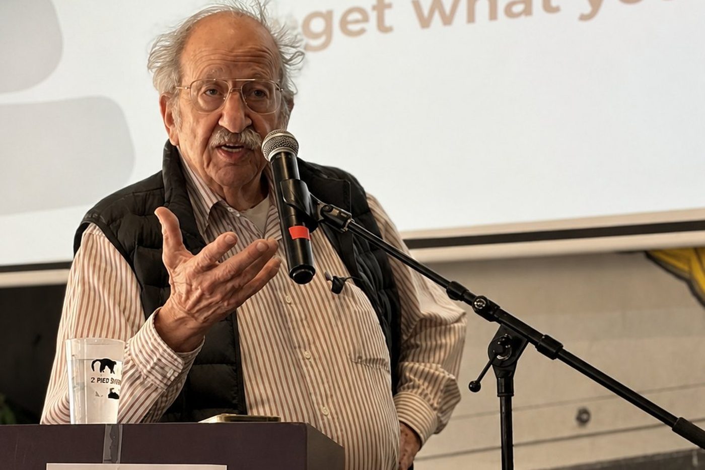 Speaker at a microphone with a simultaneous translation sign on the lectern