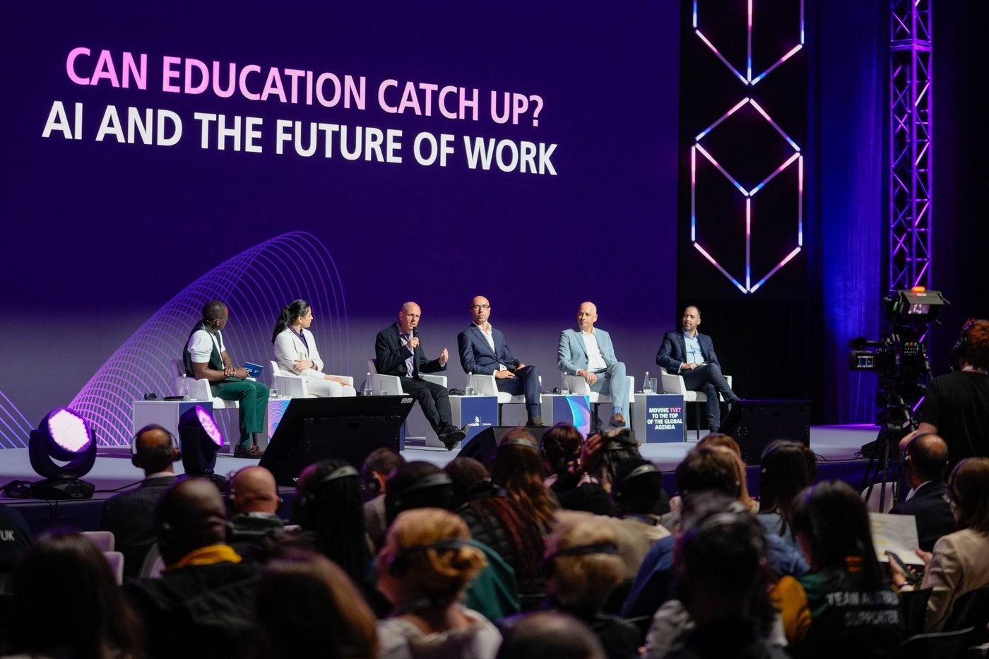 Panel on stage under the title Can education catch up? AI and the future of work